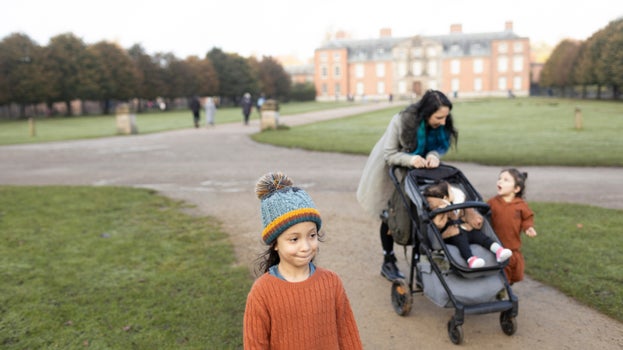 A young family on an autumn walk at Dunham Massey, Cheshire.